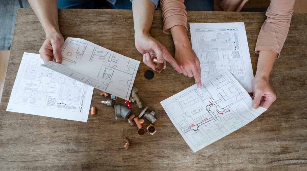 Couple trying to fix some pipes in the kitchen at home